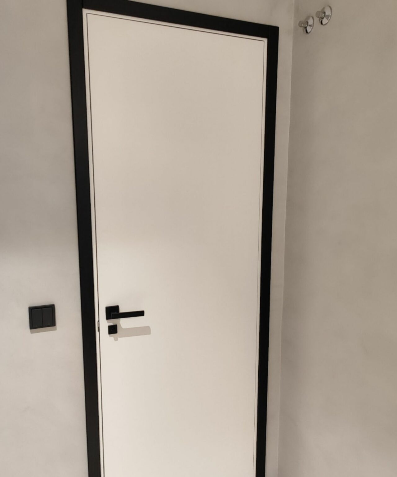 Puertas lisas blancas con tapajuntas y manillas en negro