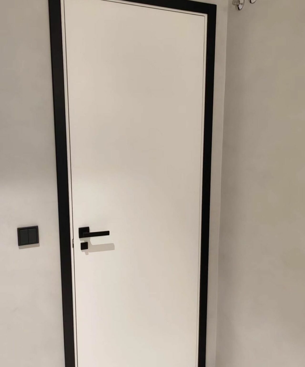 Puertas lisas blancas con tapajuntas y manillas en negro y marco negro 3