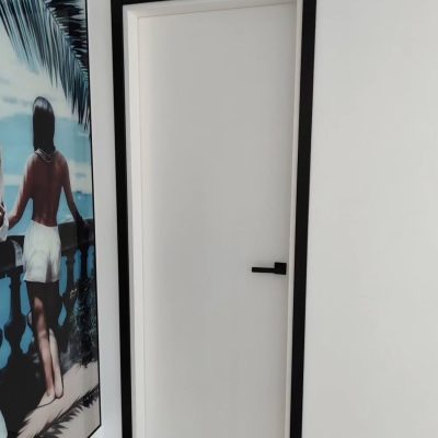 Puertas lisas blancas con tapajuntas y manillas en negro 2